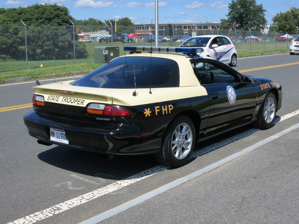 State trooper car with "STATE TROOPER" on rear spoiler, "* FHP" on side. License plate reads "1296"