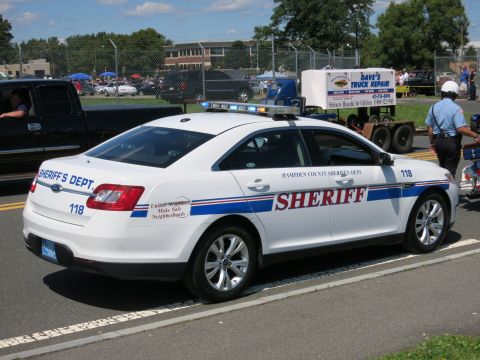 2001 Ford Crown Victoria - A sheriff's department vehicle is parked on the side of the road with a trailer and a person in uniform nearby.