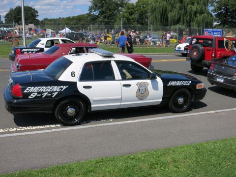 2001 Ford Crown Victoria - Side view of a police car, likely a 2001 Ford Crown Victoria, at an outdoor event.