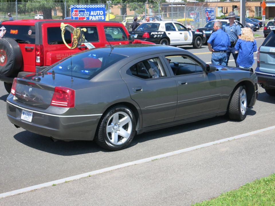 Gray Dodge Charger parked next to a red Jeep and police cars