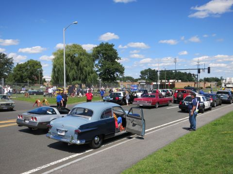 2001 Ford Crown Victoria - Cars gathered for an event on a sunny day, a classic two-tone sedan and a Corvette.