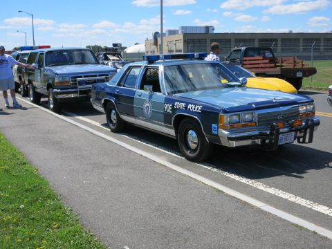 2001 Ford Crown Victoria - Massachusetts State Police car, likely a Ford Crown Victoria, parked next to a blue SUV.