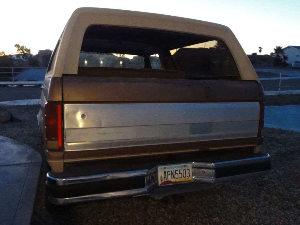 Brown and tan Ford Bronco rear view, chrome bumper, license plate APN5503
