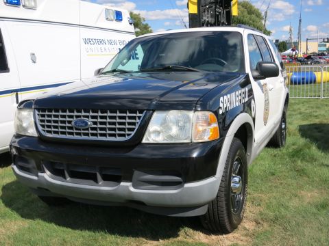 2001 Ford Crown Victoria - Ford Explorer police SUV with "SPRINGFIELD" text on the side, parked next to a Western New England University ambulance.