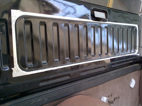 1994 Ford Bronco - Rear view of a 1994 Ford Bronco's tailgate panel, a distinctive black grille-like insert with vertical slats.