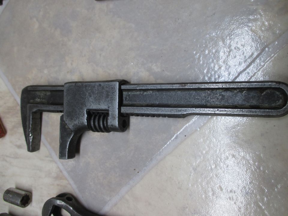 Adjustable wrench with a textured handle and a ribbed adjustment mechanism