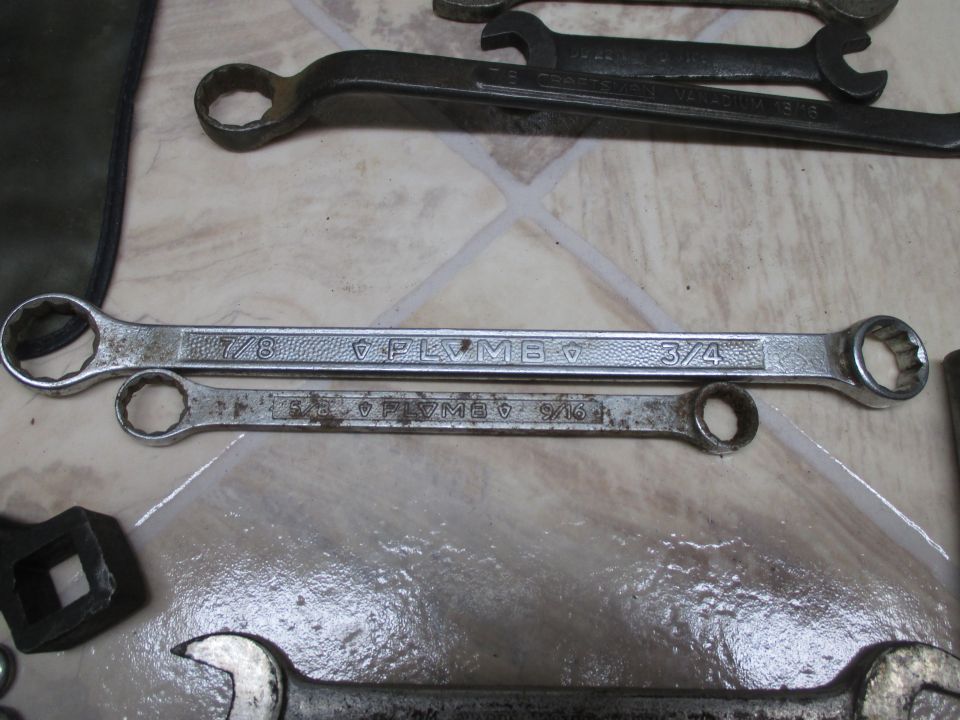 Two Plymouth brand wrenches, one 7/8 x 3/4 inch and one 1/2 x 9/16 inch, lie on a tiled surface