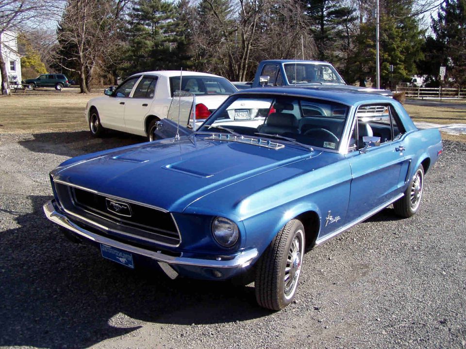 Blue 1967 Ford Mustang coupe, front 3/4 view, chrome bumper, black grille, white wall tires