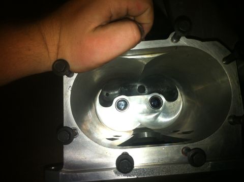 2003 Ford Crown Victoria - A hand is shown over the intake of a supercharger, revealing its internal rotors.