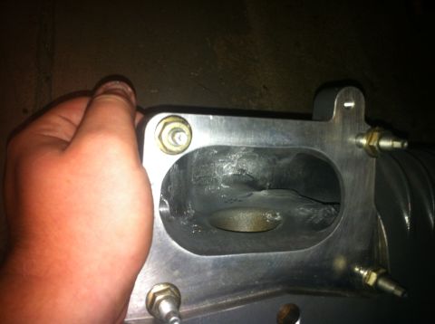 2003 Ford Crown Victoria - Close-up of an intake manifold, with a hand holding the part for scale. The Supermotors.net logo is visible in the lower right corner.
