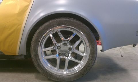 1976 Chevrolet Corvette - A car is undergoing bodywork, with a chrome wheel and a fender covered in masking tape visible.