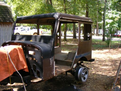 Body of a Jeep CJ-5, missing front end and doors, sitting outside