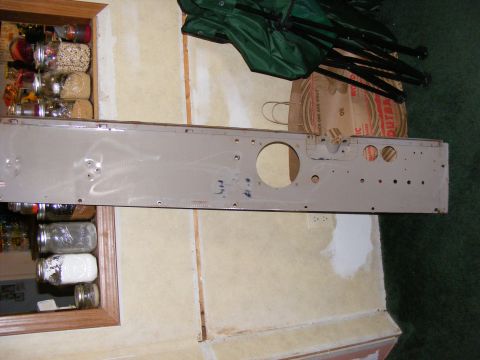 Metal panel with circular and oval cutouts, possibly for gauges