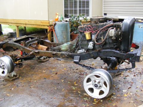 Vehicle frame with engine and transmission, wheels off. Looks like a project