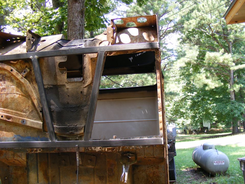 rusted vehicle body with metal frame reinforcements, outdoors