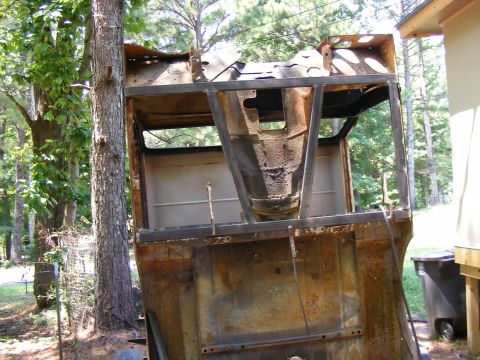 rusted vehicle body with metal frame reinforcements, outdoors