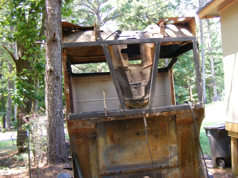 rusted vehicle body with metal frame reinforcements, outdoors