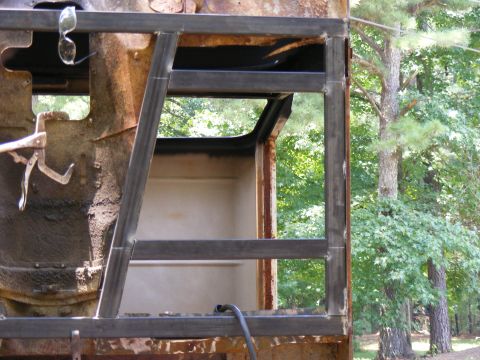 Rusted vehicle frame with custom roll cage structure welded on