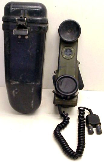 1991 Ford LTD Crown Victoria - A vintage military field telephone and its protective carrying case are displayed together.