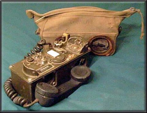 1991 Ford LTD Crown Victoria - A vintage field telephone with its handset and a canvas carrying pouch is displayed against a teal background.