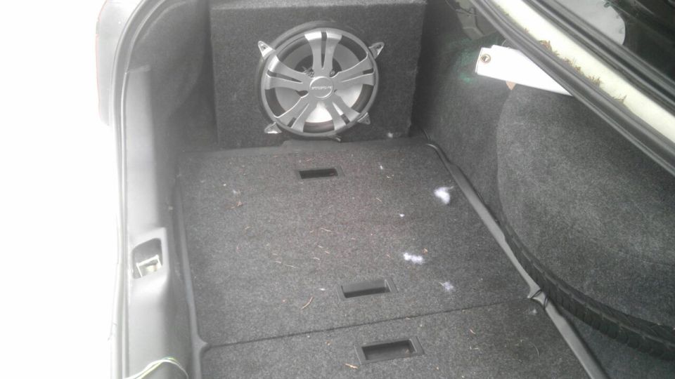 Trunk interior with aftermarket subwoofer and carpeted floor