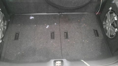 2000 Mercury Grand Marquis - The trunk of a car is shown with two subwoofers installed and a carpeted floor.