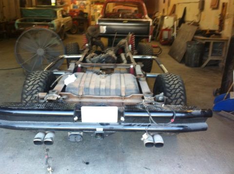 1982 Ford Bronco - The rear chassis of a 1980s Ford Bronco is visible, showing its dual exhaust pipes and trailer hitch.