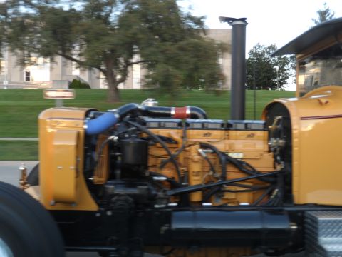 1971 Ford Ranchero - The detailed engine of a yellow truck is visible from the side, with various hoses and pipes connected.