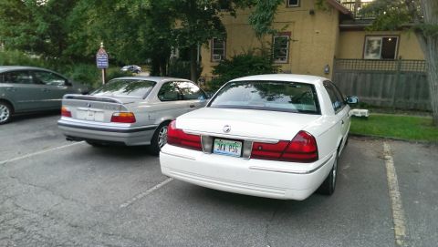 1997 BMW 3 Series - Two cars are parked in a lot. The white car is a sedan, and the silver car is a coupe.