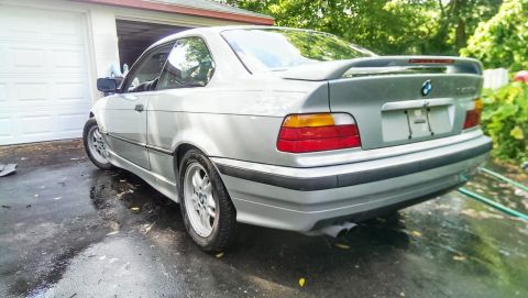 1997 BMW 3 Series - Silver 1997 BMW 3 Series coupe with a rear spoiler is parked in front of a garage.