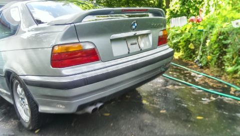 1997 BMW 3 Series - Rear view of a silver BMW 3 Series coupe, likely a 1996 model, a spoiler and dual exhaust pipes.