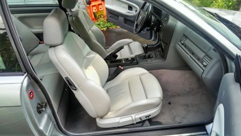 1997 BMW 3 Series - The interior of a BMW shows light gray leather seats and dashboard with a manual transmission shifter.