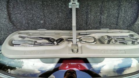 1997 BMW 3 Series - A car's trunk organizer holds various tools, including a tow hook and wrenches.