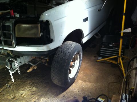 1992 Ford Bronco - Front view of a 1992 Ford Bronco undergoing repairs, with the headlight assembly missing.