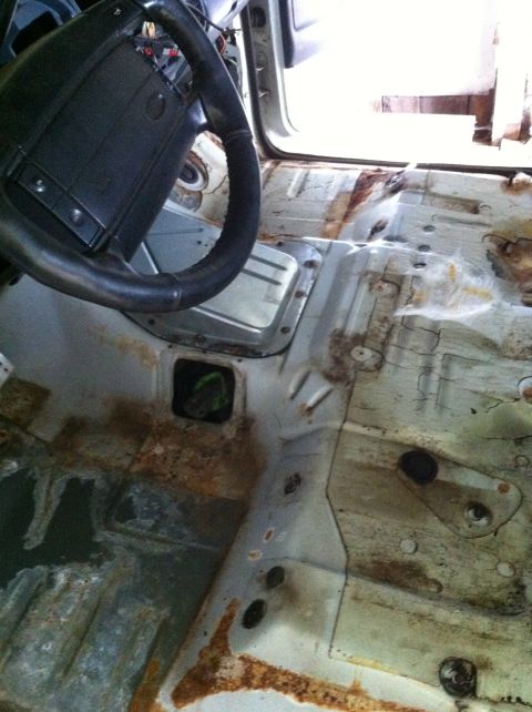 1992 Ford Bronco - The interior floor of this vehicle shows significant rust and corrosion, indicating a need for extensive repair.