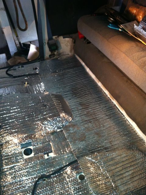 1992 Ford Bronco - Installing soundproofing material on the floor of a vehicle interior.
