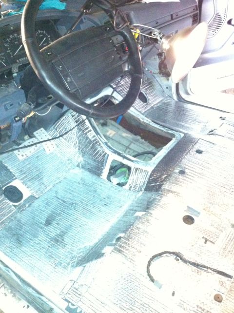1992 Ford Bronco - The interior of a vehicle is being worked on, with sound-dampening material installed on the floor and the center console removed.
