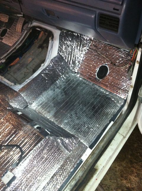 1992 Ford Bronco - Silver insulation covers the floor of a vehicle interior, with pedals and dashboard visible.