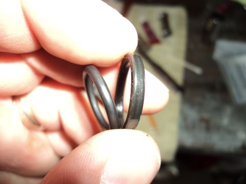 2004 Mercury Grand Marquis - Close-up of two rubber o-rings being held by fingers, with a workshop background.