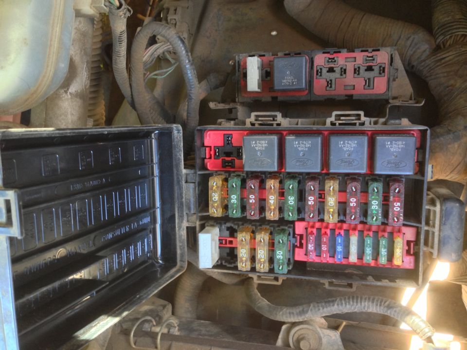 Vehicle fuse box with multiple relays and fuses, some labeled with amperage