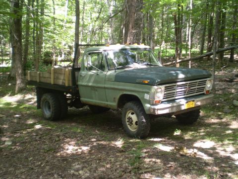 1979 Ford Bronco - This flatbed truck, likely a 1969 Ford F-Series, is parked amongst trees.