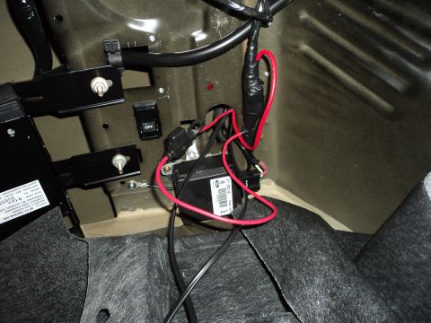 2004 Mercury Grand Marquis - Close-up of aftermarket electrical components installed in a vehicle's trunk.