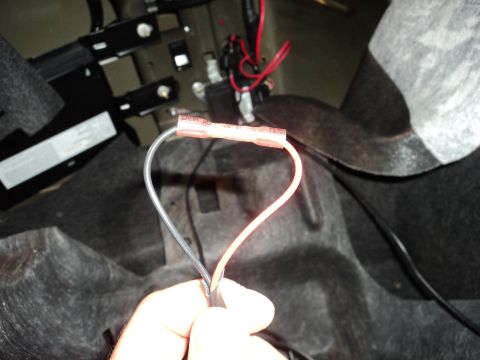 2004 Mercury Grand Marquis - Close-up of a wire splice in a vehicle's trunk, showing red and black wires connected.