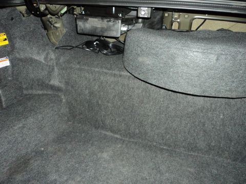 2004 Mercury Grand Marquis - Interior view of a car's trunk, showing carpeting and a spare tire cover.