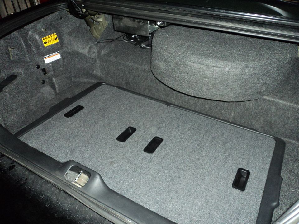Trunk interior with spare tire cover and carpeted floor