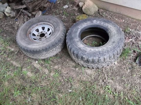 1995 Ford Bronco - Two tires are shown on the ground, one with visible text identifying it as 'WILD COUNTRY'.