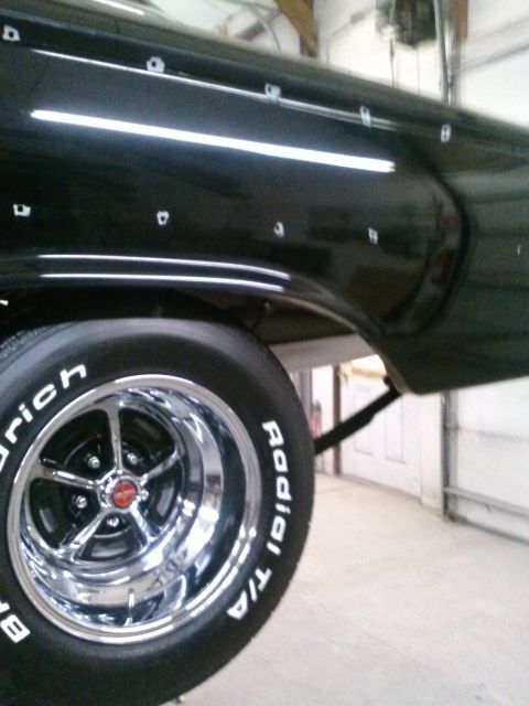 1960 Ford Falcon - Close-up view of the rear quarter panel and wheel of a black car, chrome accents and BFGoodrich Radial T/A tires.