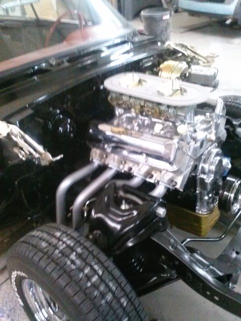 1960 Ford Falcon - Close-up of a V8 engine with dual carburetors and chrome headers, likely undergoing restoration or modification.