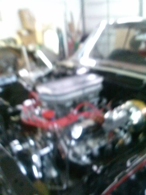 1960 Ford Falcon - Close-up view of an engine bay, showing a carburetor and red spark plug wires.