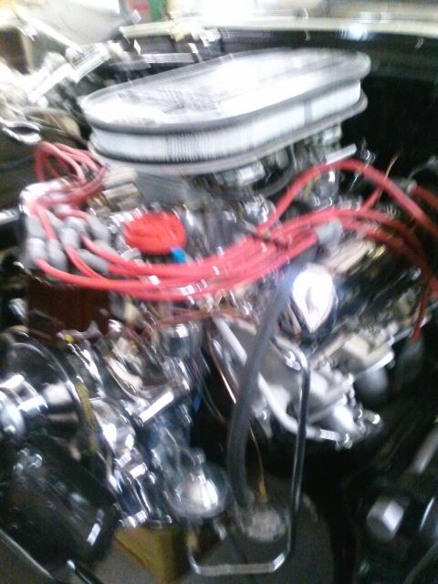 1960 Ford Falcon - A close-up view of a vehicle's engine bay, red spark plug wires and chrome components.